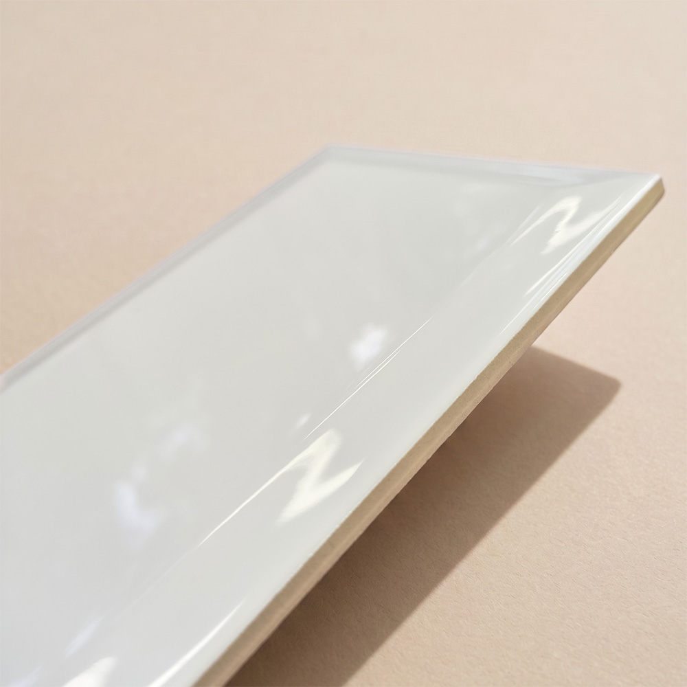 Bevelled edge ceramic tile with a high gloss finish reflecting light