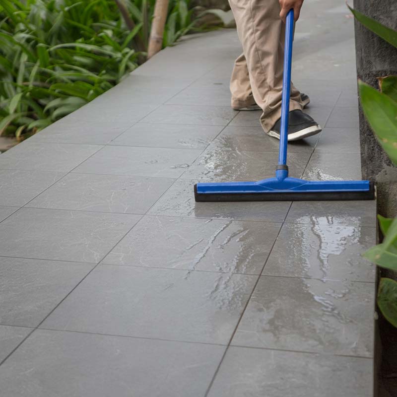 Washing outdoor tiles and pavers to remove built-up dirt, grime, and debris