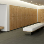 Communal changing room with slip-resistant P3 floor tiles designed for wet conditions, with benches and lockers visible.