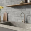 A modern kitchen featuring a marble counter, and stylish Solar Ash matt tiles on the splashback.