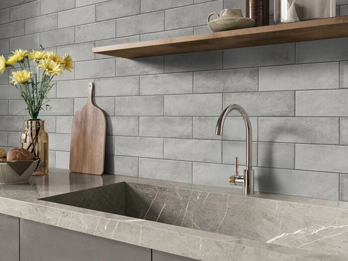 A modern kitchen featuring a marble counter, and stylish Solar Ash matt tiles on the splashback.