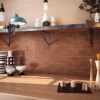 Charming kitchen showcasing wooden shelves and counter, complemented by elegant Solar Brick gloss tiles for added flair.