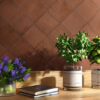 A charming table with three flower vases and books, beautifully placed on diamond-patterned Solar Brick matt tiles.